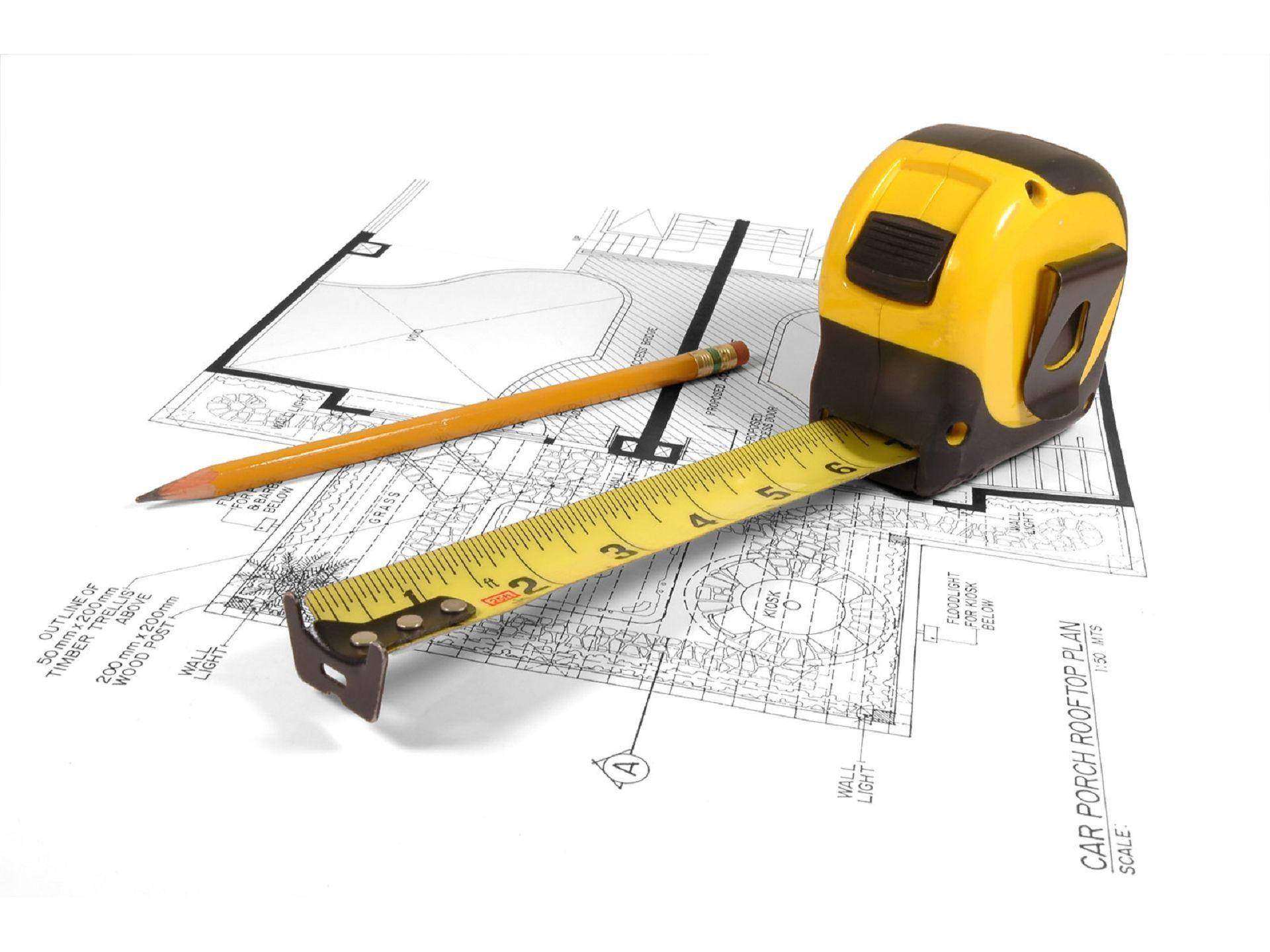 pencil and tape measure over blueprints