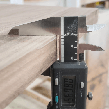 a digital caliper measuring wood